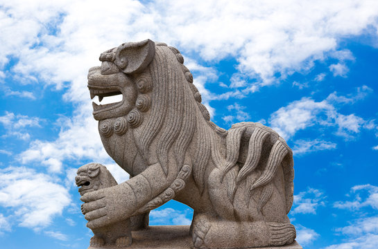Chinese lion stone statue On the background of the bright sky