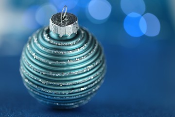 Christmas and New Year decor. Blue  holiday ball decoration on a dark blue background with shining bokeh.winter festive background.Phone christmas wallpaper.Winter holidays.