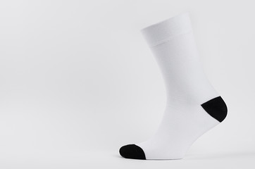 Blank white cotton long sock with black heel on invisible  foot on white background as mock up for...