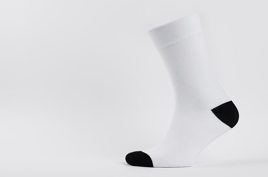 Blank white cotton long sock with black heel on invisible  foot on white background as mock up for advertising, branding, design, side view, template.