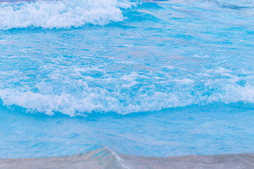 Naklejka na ściany i meble Blue wave on a beach
