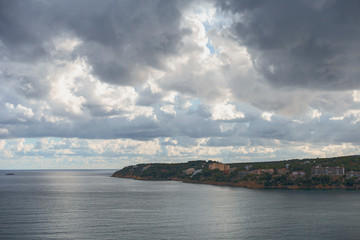 view of the quiet bay and rocky coast of the Spanish resort town of Magaluf against the evening cloudy sky