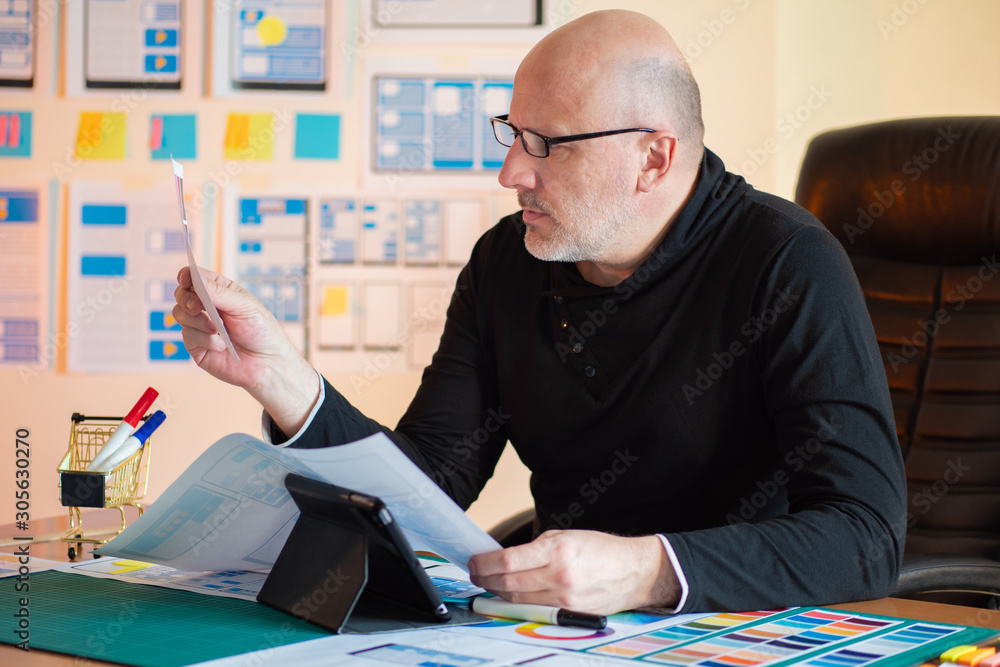 Poster designer is focused on work. profession mobile app designer. work with color choices. mobile app dev
