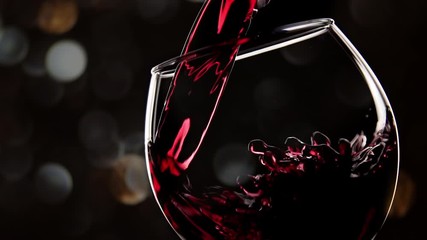 Red wine pouring in glass. Christmas celebration, slow motion, close up