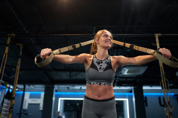 Fototapeta na wymiar Athletic woman on arm muscle training with elastic