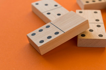 Playing dominoes on a orange table. Leisure games concept. Domino effect.