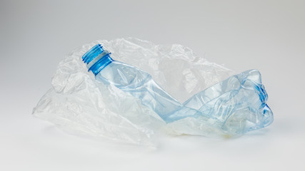 Plastic bottle with cellophane bag on a light background. The concept of ecology.