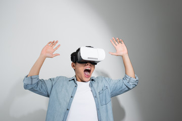 young happy and excited Asian man wearing virtual reality vr 360 vision goggles enjoying video game