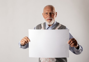 Old man is holding white paper.