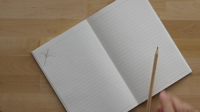 Man put cross over written number one at empty notepad page and put pencil down, it roll away. Top view of wooden table at home, concept of hard start planning