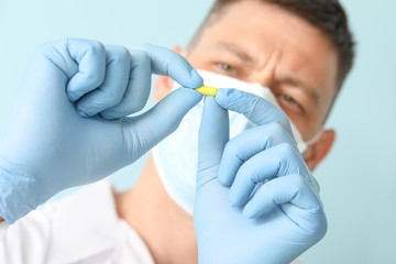 Doctor with medicine on color background