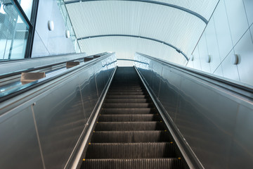 Escalator in Community Mall, Shopping Center. Moving up staircase.