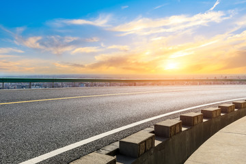 Shanghai city skyline and empty asphalt road scenery at sunset.
