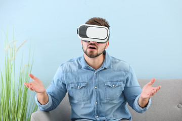 Young man with virtual reality glasses at home