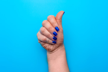 Female hand with dark blue nails showing gesture