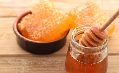 Honey in glass jar with honeycombs and dipper