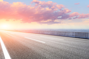 Shanghai city skyline and empty asphalt road scenery at sunset.
