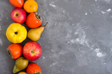 Different seasonal fruits on a concrete background. Source of vitamins and health. Healthy eating concept. Copy space.