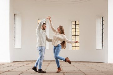 Loving young couple dancing in building