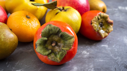 Different seasonal fruits on a concrete background. Source of vitamins and health. Healthy eating concept.