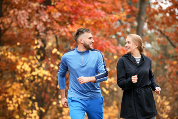 Fototapeta premium Loving young couple running in autumn park