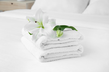 Clean soft towels and flowers on bed