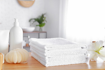 Obraz na płótnie Canvas Soft towels and cosmetics on table in bathroom