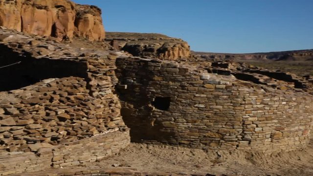 Quick pan from a brick lined hole in the ground that was used for cultural religious ceremonies thousands of years ago by the Anasazi people. This is a kiva at Chetro Ketl at Chaco Canyon, New Mexico.