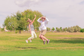 Fototapeta na wymiar young couple jumping in a green field