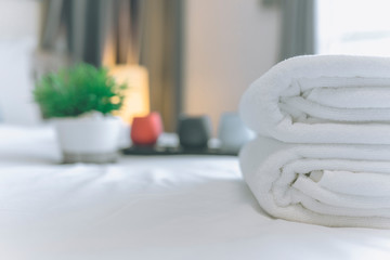 Obraz na płótnie Canvas White towel on bed in guest room for hotel customer. Towels in spa or fitness center.