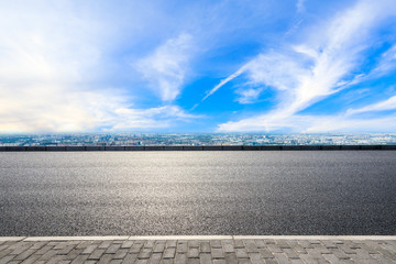 Asphalt highway and city skyline with clouds scenery in Shanghai.