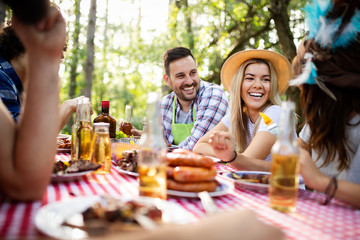 Friends having a barbecue party and fun in nature