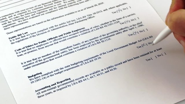 Human puts checkbox in a Independent Accountant's Review Report and writing signature of the document. Close-up
