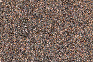 Background of evenly distributed poppy seeds in different colors