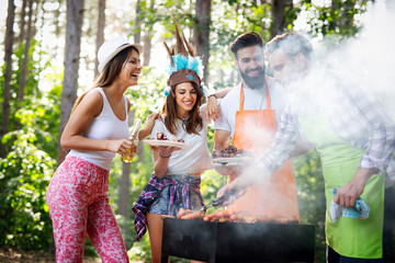 Group of happy friends having outdoor barbecue party and fun together