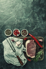 Beef steaks with rosemary on wooden board
