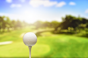 Close up of golf ball on tee in the lawn With the red light shining in at sunrise or sunset. Soft select focus