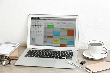 Modern laptop with calendar app in office