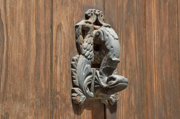 Fototapeta na wymiar Iron zoological door knob on the ancient wooden door