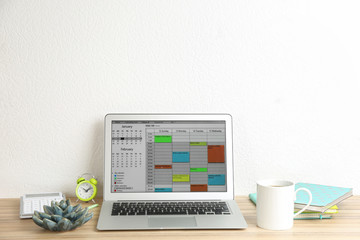 Modern laptop with calendar app in office