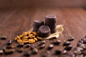Pieces of handmade chocolate with almonds and cocoa beans on wooden board - Guatemalan chocolate