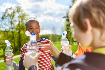 Kinder erfrischen sich mit Wasser aus Flaschen