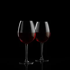 Fotobehang Two red wine glasses on a black background © zakiroff