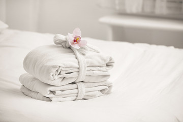 Clean folded bathrobes on bed in room, space for text