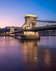 Amazing photo about Szechenyi Chain bridge with danube river. Splendid purple sunset lights. Budapest, Hungary.