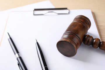Clipboard with gavel on wooden table. Domestic violence law concept