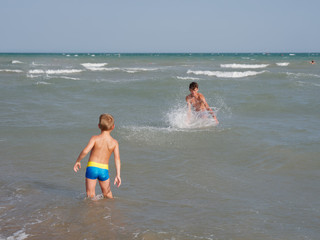 Children swim in the sea on the beach in Bibione, Italy