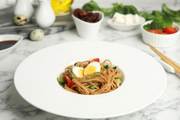 Tasty buckwheat noodles served on white marble table