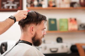 Hairdressing services. A man cuts hair at a hairdresser-stylist in a barbershop. 