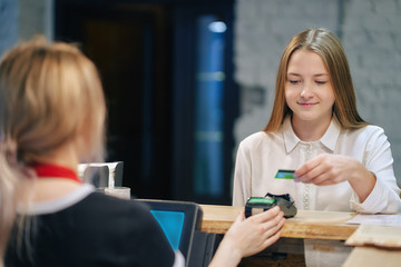 student girl pays order in cafe by credit card